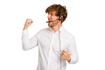 Telemarketer man working with a headset isolated on green chroma background raising fist after a victory, winner concept.