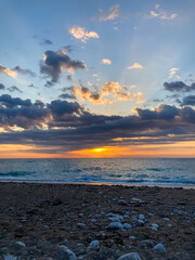 Sunrise landscape with clouds and sea. View of the sun rising above the sea. Selective focus.