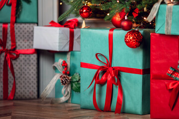 Closeup gift box with bowknot on blurred background red decorated christmas tree pine bokeh sun light banner