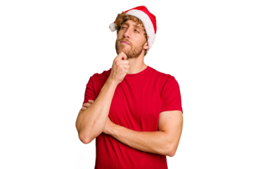 Young caucasian man wearing a Christmas Santa hat isolated on white background looking sideways with doubtful and skeptical expression.