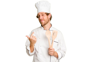 Young cook man isolated on white background pointing with finger at you as if inviting come closer.
