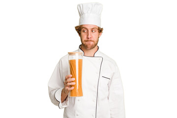 Young cook man isolated on white background confused, feels doubtful and unsure.