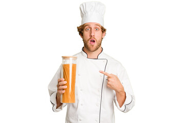 Young cook man isolated on white background pointing to the side