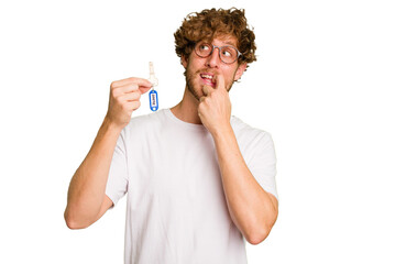 Young caucasian man holding home keys isolated on white background relaxed thinking about something looking at a copy space.