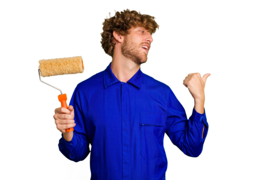 Young painter man holding a roll isolated on white background points with thumb finger away, laughing and carefree.