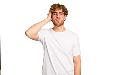 Naklejka premium Young caucasian man isolated on green chroma background tired and very sleepy keeping hand on head.