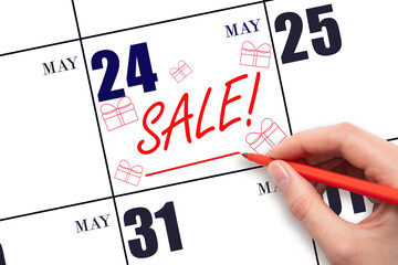 Hand writing text SALE and drawing gift boxes on calendar date May 24. Shopping Reminder