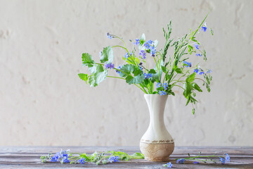 wild flowers  in vase  on background white old wall