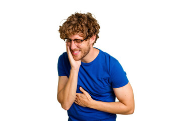 Obraz premium Young caucasian man isolated on green chroma background laughs happily and has fun keeping hands on stomach.