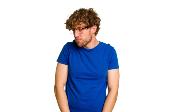 Young caucasian man isolated on green chroma background shrugs shoulders and open eyes confused.