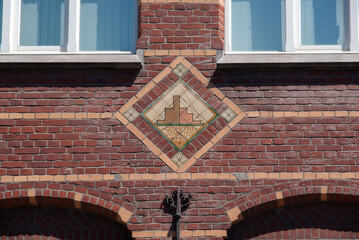 Wall of dark red tiles with Dutch text
translation: geometry, stability, proportion