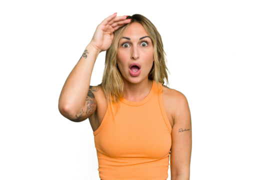 Young caucasian woman isolated on green chroma background shouts loud, keeps eyes opened and hands tense.