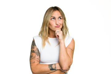 Young caucasian woman isolated on green chroma background thinking and looking up, being reflective, contemplating, having a fantasy.