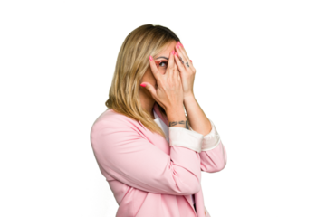 Young caucasian woman isolated on green chroma background blink through fingers frightened and nervous.