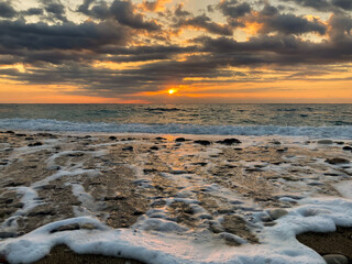 Sunrise landscape with clouds and sea. View of the sun rising above the sea. Selective focus.