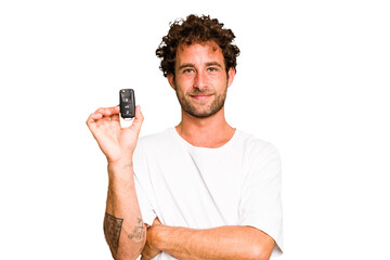 Young caucasian man holding car keys isolated laughing and having fun.