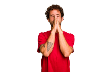 Young caucasian curly hair man isolated Young caucasian man with curly hair isolated holding hands in pray near mouth, feels confident.