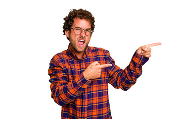Fototapeta premium Young caucasian curly hair man isolated Young caucasian man with curly hair isolated pointing with forefingers to a copy space, expressing excitement and desire.