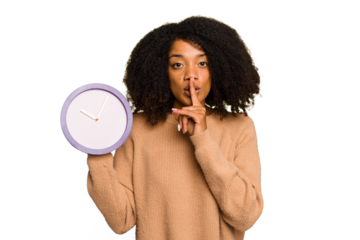 Young African American holding a clock isolated keeping a secret or asking for silence.
