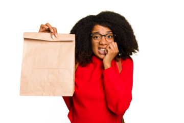 Young African american woman holding take away food isolated biting fingernails, nervous and very anxious.