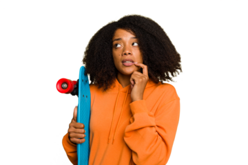 Young skater African American woman holding a little skate isolated relaxed thinking about something looking at a copy space.