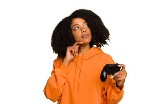 Young African American woman holding a game controller isolated looking sideways with doubtful and skeptical expression.
