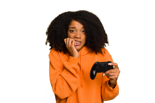 Young African American woman holding a game controller isolated biting fingernails, nervous and very anxious.