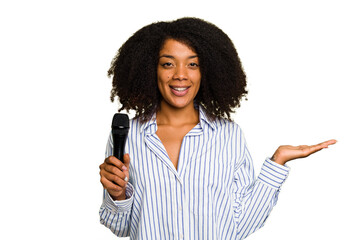 Young African American singer woman holding a microphone isolated showing a copy space on a palm...