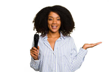 Young African American singer woman holding a microphone isolated showing a copy space on a palm and holding another hand on waist.