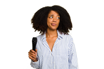 Young African American singer woman holding a microphone isolated confused, feels doubtful and unsure.