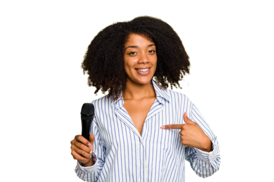 Young African American singer woman holding a microphone isolated person pointing by hand to a shirt copy space, proud and confident