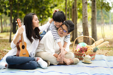 Happy Asian family have good summer moment spend time and enjoy play together on holiday in the park with no generation gap good relationship lifestyle and insurance concept