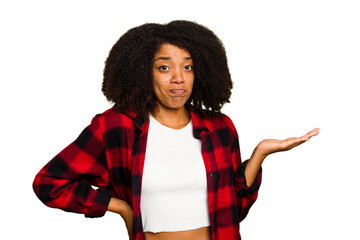 Young African American woman isolated showing a copy space on a palm and holding another hand on waist.