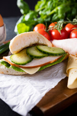 Sandwich on a wooden cutting board, selective focus, with blurred background. Breakfast concept.