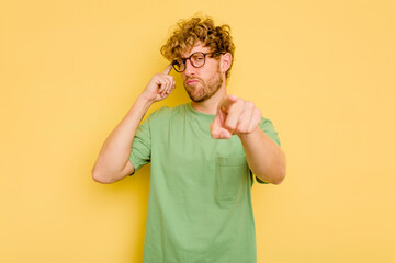 Young caucasian man isolated on yellow background pointing temple with finger, thinking, focused on...