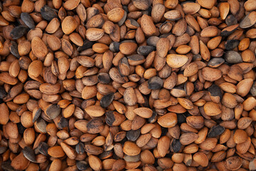 Almond background texture of nuts, unshelled and unprocessed healthy food, in warm autumnal tones