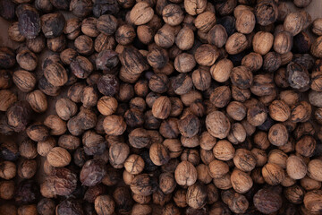 Walnuts background texture, unshelled and unprocessed healthy food, in warm autumnal tones