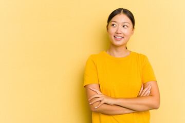 Obraz premium Young Asian woman isolated on yellow background smiling confident with crossed arms.