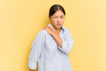 Young Asian woman isolated on yellow background having a shoulder pain.