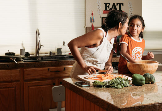 Cooking with Mom in the kitchen indoors with daughter