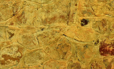 Close-up on a handcrafted stonewall built with rough hand axed stones