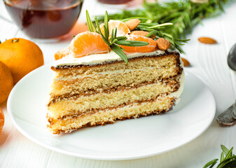 Cake with tangerines and rosemary on a light table. Up close