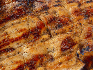 Detail of a well-cooked, golden and crispy grilled chicken breast