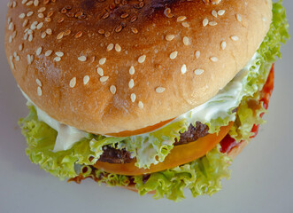Angus burger with mayonnaise, ketchup, tomato and lettuce on sesame seed bun