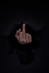 Fuck you sign by hand isolated on black background. Offensive gesture