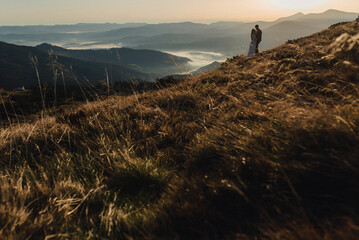 Wedding couple looking in mountain hill on sunset