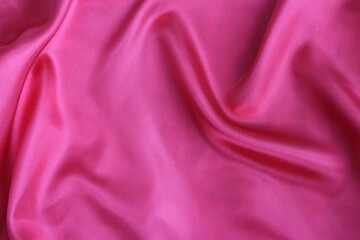 Beautiful bright pink fabric, folded in soft folds. Silk, satin or satin ribbon.