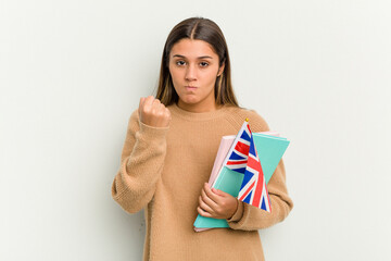 Young Indian woman holding an United Kingdom flag isolated on white background showing fist to camera, aggressive facial expression.