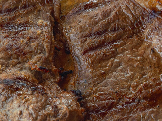 Detail of a well cooked grilled steak with marked lines and juicy