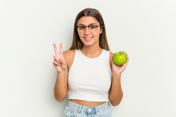 Young Indian woman holding an apple isolated on white background showing number two with fingers.